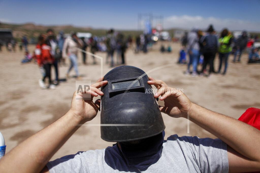 Natacha Pisarenko Using a welder's mask as protection, a man views a total eclipse in Piedra del Aguila, Argentina, Monday, Dec. 14, 2020. The total solar eclipse was visible from the northern Patagonia region of Argentina and from Araucania in Chile, and as a partial eclipse from the lower two-thirds of South America. (AP Photo/Natacha Pisarenko)