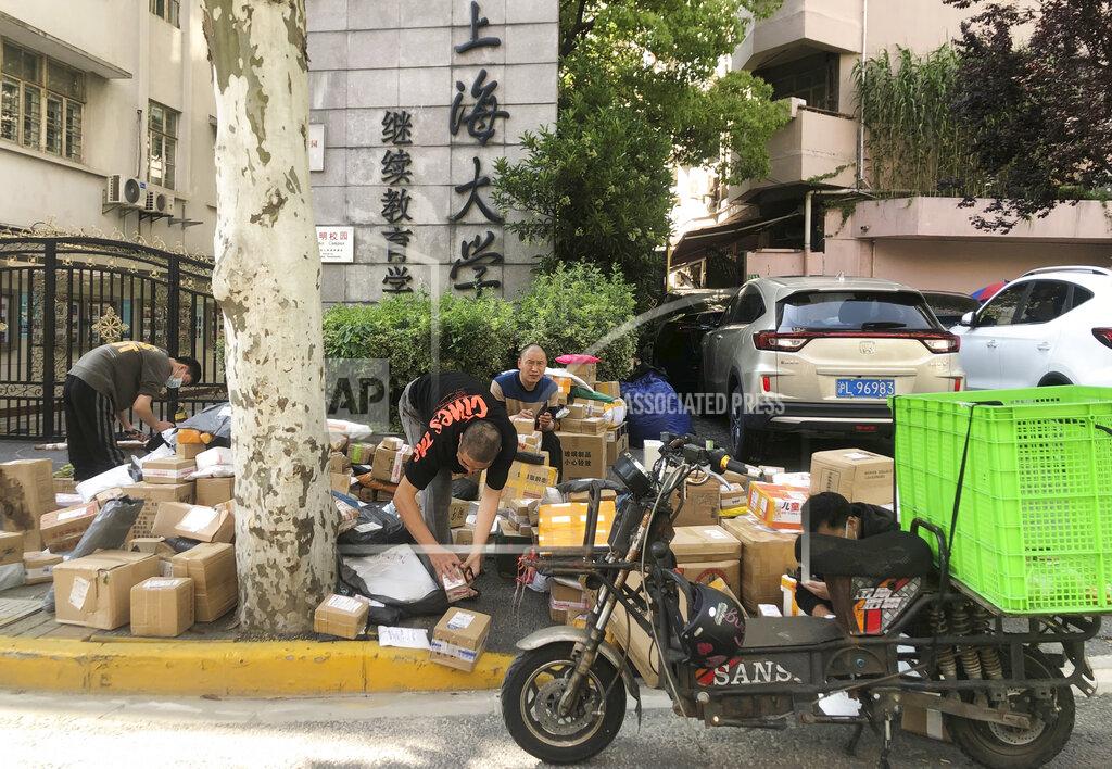 Chen Si Delivery men sort out parcels on the street in Shanghai, China, Sunday, May 22, 2022. Numerous residential compounds in Beijing have restricted movement in and out, although conditions remain far less severe than in Shanghai, where millions of citizens have been under varying degrees of lockdown for two months. (AP Photo/Chen Si)