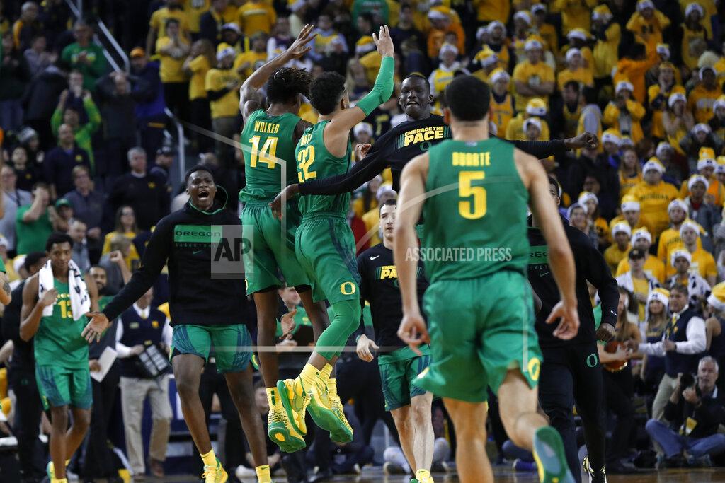 Paul Sancya Oregon players celebrate their 71-70 overtime win against Michigan after an NCAA college basketball game in Ann Arbor, Mich., Saturday, Dec. 14, 2019. (AP Photo/Paul Sancya)