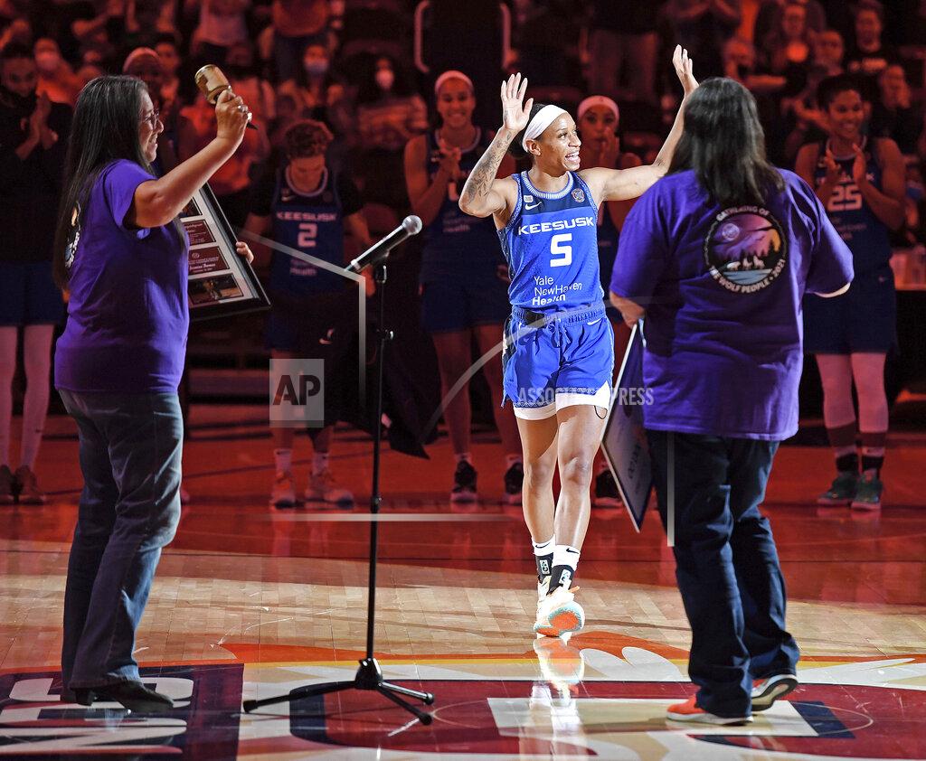 Sean D. Elliot Connecticut Sun guard Jasmine Thomas (5) comes forward to accept the inaugural Gladys Tantaquidgeon Award from members of the Mohegan Tribe Council of Elders on the court after a win over the Atlanta Dream in a WNBA basketball game Sunday, Sept. 19, 2021, in Uncasville, Conn. (Sean D. Elliot/The Day via AP)