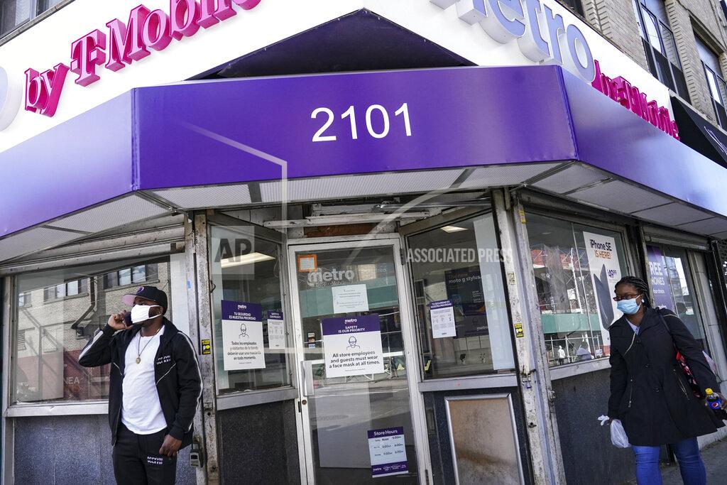 John Minchillo Pedestrians in masks pass a storefront on Thursday, Oct. 15, 2020, as restrictions are imposed on the area due to an increase in COVID-19 infections in the Far Rockaway neighborhood of the borough of Queens in New York. After shutdowns swept entire nations during the first surge of the coronavirus earlier this year, some countries and U.S. states are trying more targeted measures as cases rise again around the world. (AP Photo/John Minchillo)