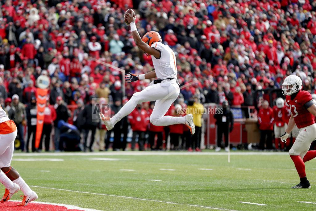 Nati Harnik Illinois quarterback AJ Bush Jr. (1) leaps into the end zone for a touchdown ahead of Nebraska defensive back JoJo Domann (13), during the first half of an NCAA college football game in Lincoln, Neb., Saturday, Nov. 10, 2018. (AP Photo/Nati Harnik)