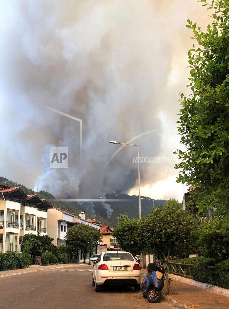 Patrizia Under Smoke rises from a forest fire close to a touristic hotel in Icmeler area in the Aegean coastal town of Marmaris, Turkey, Thursday, July 29, 2021. At least three people were killed and dozens of people were hospitalized in Manavgat in southern Turkey after strong winds fanned several separate forest fires, officials said Thursday. (AP Photo/Patrizia Under)