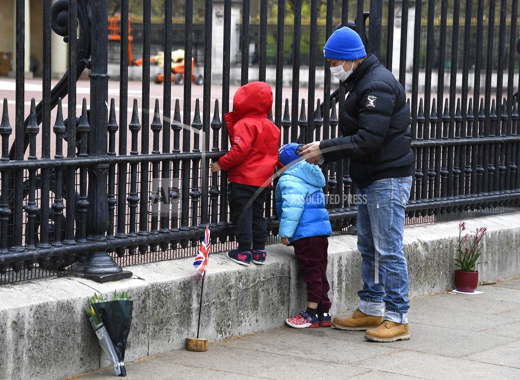 Alberto Pezzali A child peers through the gates of Buckingham Palace in London, a day after the death of Britain's Prince Philip, Saturday, April 10, 2021. Britain's Prince Philip, the irascible and tough-minded husband of Queen Elizabeth II who spent more than seven decades supporting his wife in a role that mostly defined his life, died on Friday. (AP Photo/Alberto Pezzali)