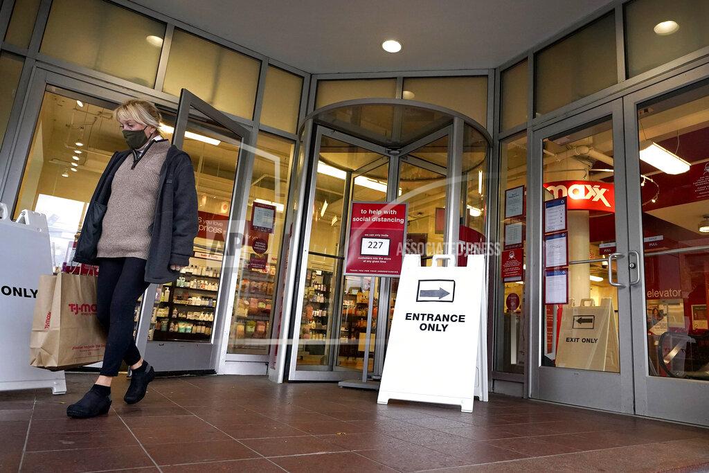 Steven Senne FILE - In this Oct. 27, 2020, file photo, a shopper steps out of a department store in Boston. Defying fears of another slowdown, U.S. businesses kept hiring at a solid pace in October yet there are signs they remain cautious about the economy's future as the pandemic worsens. (AP Photo/Steven Senne, File)
