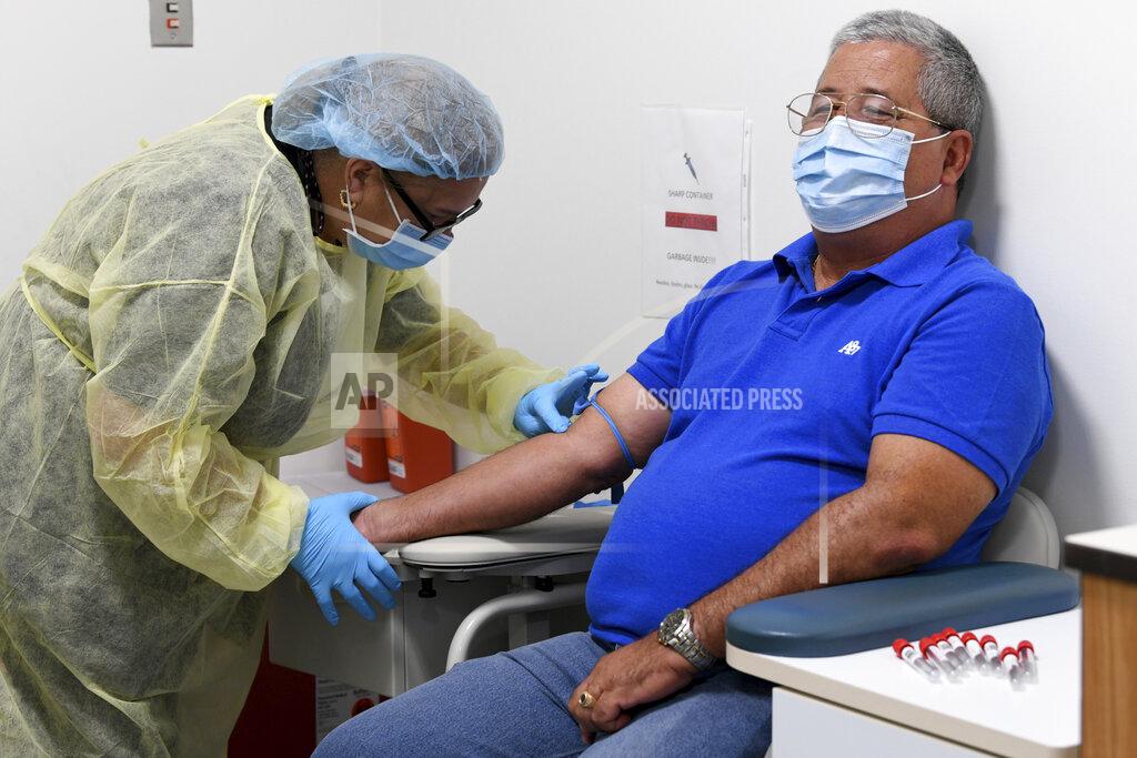 Taimy Alvarez University of Miami Miller School of Medicine phlebotomist Mayra Fernandez prepares to take a blood sample from study participant Julio Li, Wednesday, Sept. 2, 2020, in Miami. Miami is one of 89 cities around the U.S. that's testing the Moderna COVID-19 vaccine. (AP Photo/Taimy Alvarez)