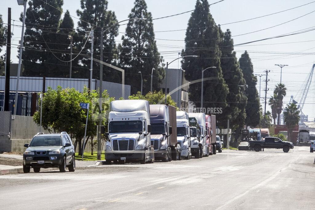 Ringo H.W. Chiu Parked cargo container trucks are seen in a street, Wednesday, Oct. 20, 2021 in Wilmington, Calif. California Gov. Gavin Newsom on Wednesday issued an order that aims to ease bottlenecks at the ports of Los Angeles and Long Beach that have spilled over into neighborhoods where cargo trucks are clogging residential streets. (AP Photo/Ringo H.W. Chiu)