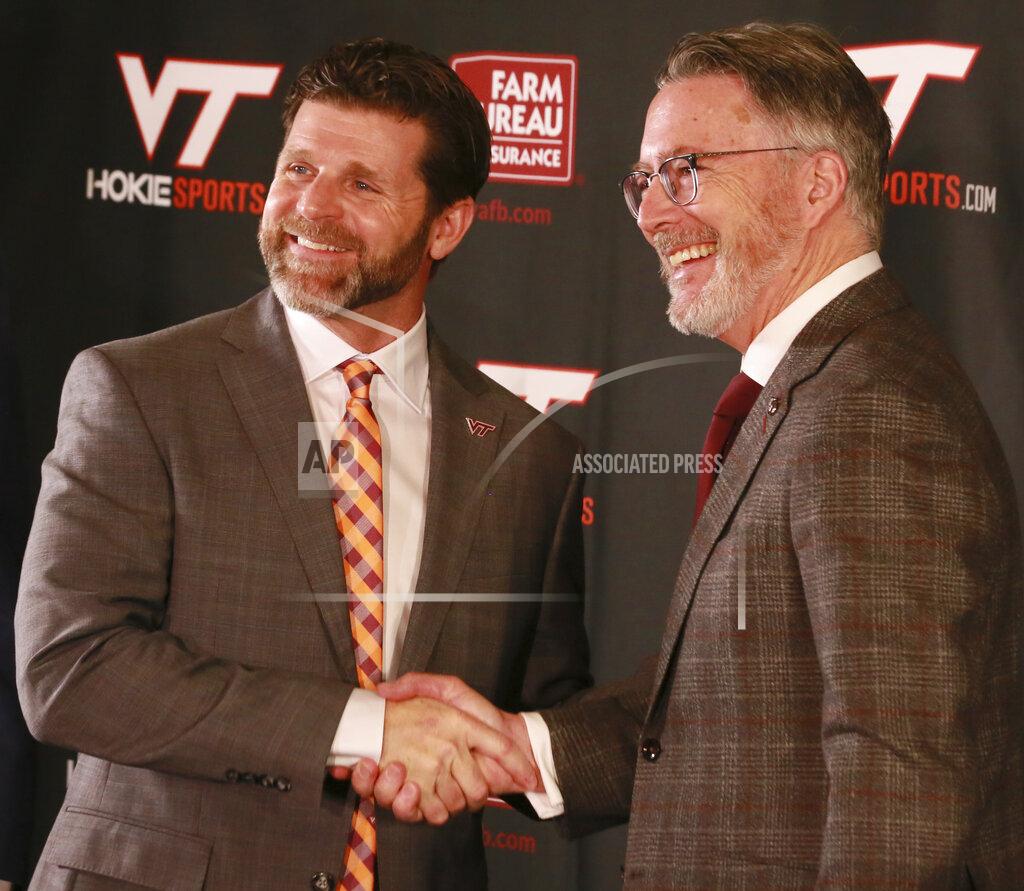Matt Gentry New Virginia Tech NCAA college football head coach Brent Pry, left, poses with Virginia Tech President Tim Sands during an introductory press conference in Blacksburg Va., Thursday Dec. 2, 2021. (Matt Gentry/The Roanoke Times via AP)/The Roanoke Times via AP)