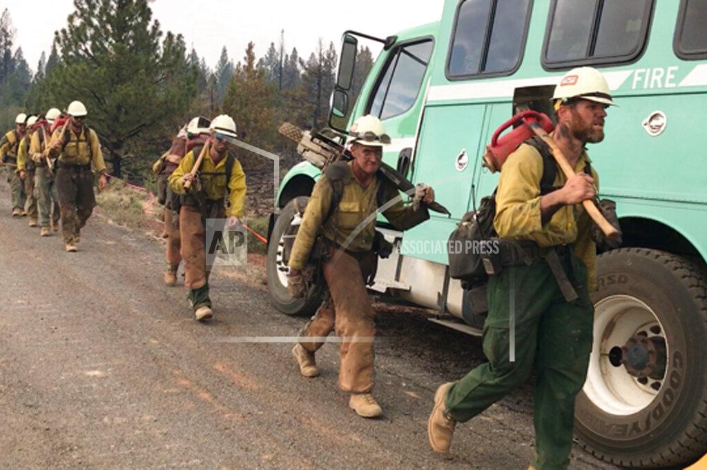Uncredited In this photo provided by the Bootleg Fire Incident Command, a handcrew walks to engage the Bootleg Fire in southern Oregon on Monday, July 19, 2021. The Oregon fire has ravaged the southern part of the state and has been expanding by up to 4 miles (6 kilometers) a day, pushed by gusting winds and critically dry weather that's turned trees and undergrowth into a tinderbox. (Bootleg Fire Incident Command via AP)