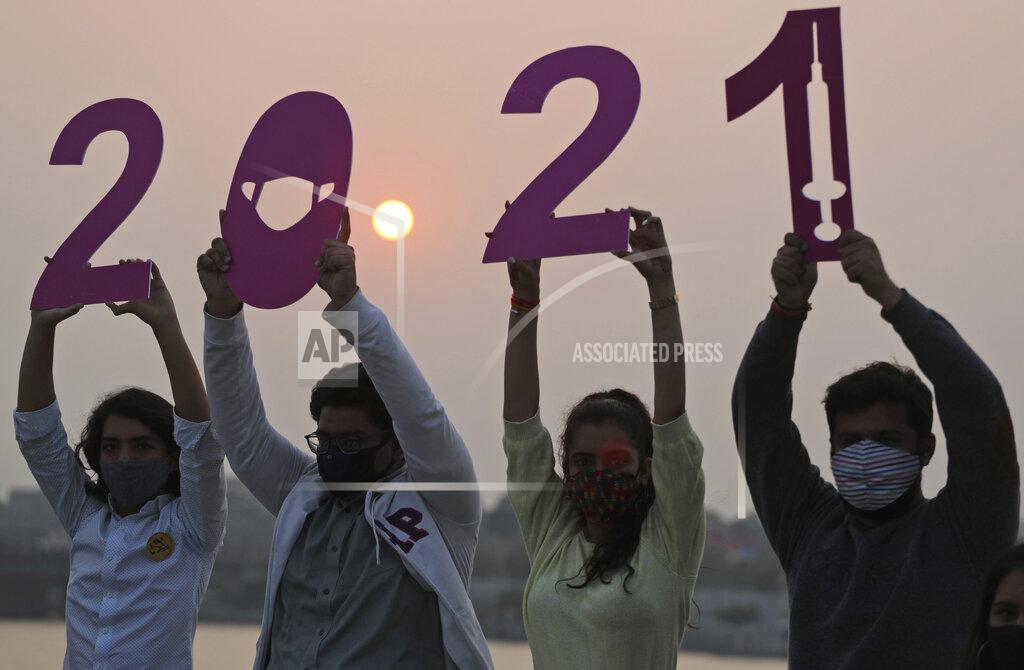 Ajit Solanki Indians hold cutouts welcoming the New Year on the eve of New Year in Ahmedabad, India, Thursday, Dec. 31, 2020. (AP Photo/Ajit Solanki)
