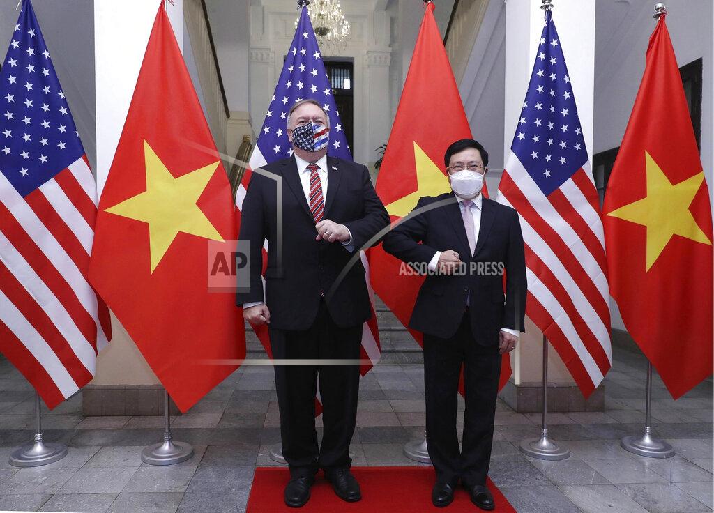 Bui Lam Khanh U.S. Secretary of State Mike Pompeo, left, and Vietnamese Foreign Minister Pham Binh Minh gesture with their elbows while posing for a photo before a meeting in Hanoi, Vietnam, Friday, Oct. 30, 2020. Pompeo is wrapping up an anti-China tour of Asia in Vietnam as the fierce American presidential election race enters its final stretch. (Bui Lam Khanh/VNA via AP)