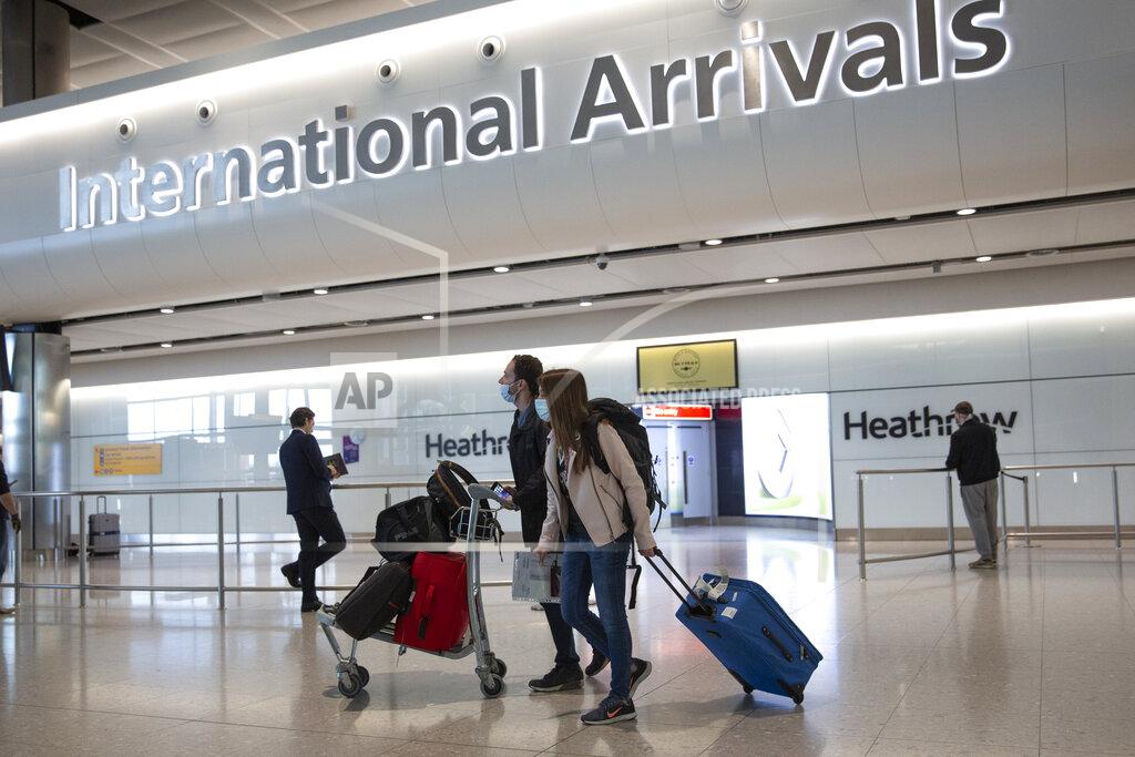 Matt Dunham Passengers wearing face masks arrive on the first day of new rules that people arriving in Britain from overseas will have to quarantine themselves for 14 days to help stop the spread of coronavirus, at Heathrow Airport in London, Monday, June 8, 2020. The British government has said that anyone caught not complying with the quarantine will face a fine. (AP Photo/Matt Dunham)