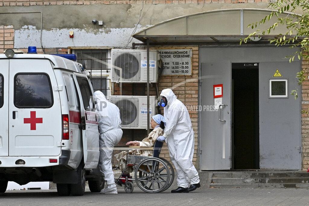 Uncredited Medical workers wearing protective gear transport a patient suspected of having coronavirus from an ambulance to a hospital in Rostov-on-Don, Russia, Thursday, Oct. 22, 2020. Russia is facing a sharp rise in infections, but the Kremlin has ruled out a new lockdown. (AP Photo)