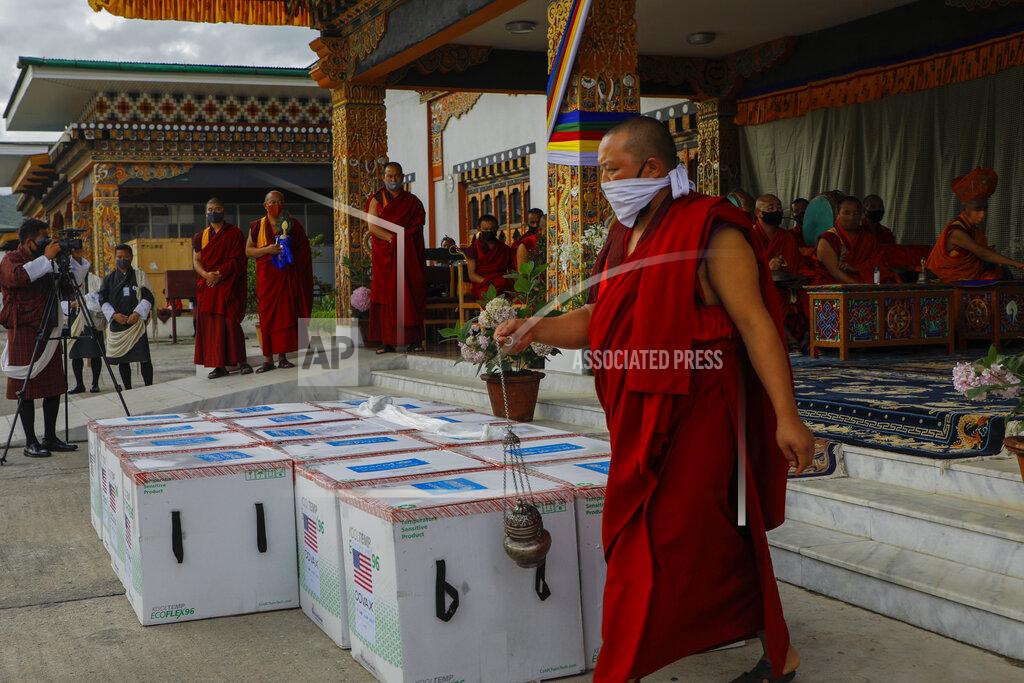 Uncredited This photograph provided by UNICEF shows monks from Paro's monastic body perform a ritual as 500,000 doses of Moderna COVID-19 vaccine gifted from the United States arrived at Paro International Airport in Bhutan, July 12, 2021. The Himalayan kingdom of Bhutan has fully vaccinated 90% of its eligible adult population within just seven days, its health ministry said Tuesday. (UNICEF via AP)