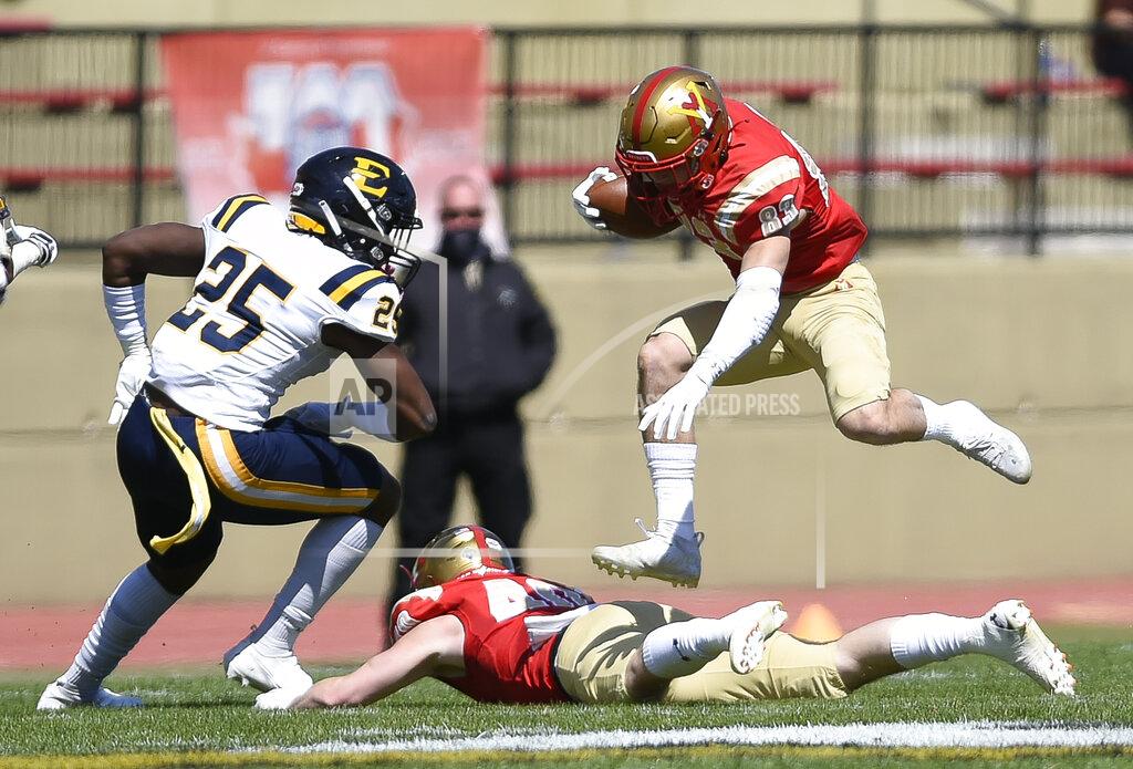 David Hungate VMI Chance Knox (83) leaps over teammate Grant Swinehart (40) while EEast Tennessee State's D'Andre Davis (25) reacts during the first half of an NCAA college football game Saturday, April 3, 2021, in Lexington, Va. (David Hungate/The Roanoke Times via AP)