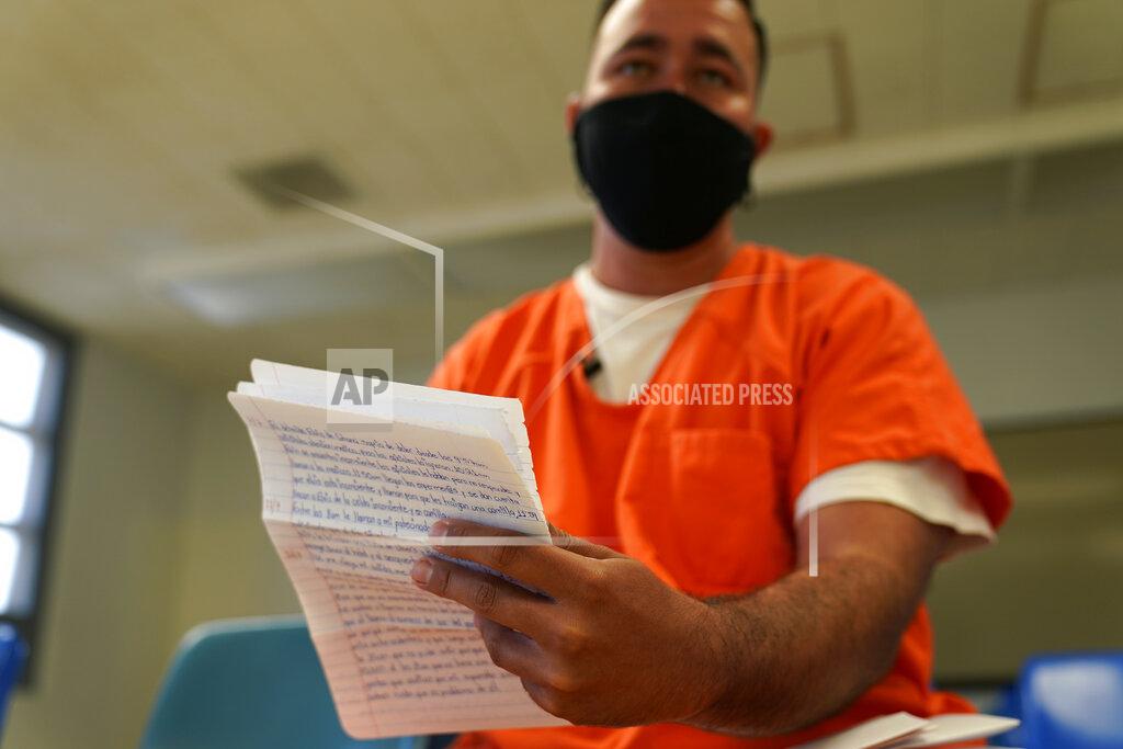 Gerald Herbert Immigration detainee Alexander Martinez shows his handwritten notations of allegations of abusive treatment, as he speaks during an interview with The Associated Press inside the Winn Correctional Center in Winnfield, La., Friday, July 30, 2021. (AP Photo/Gerald Herbert)