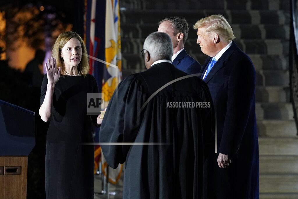 Patrick Semansky President Donald Trump watches as Supreme Court Justice Clarence Thomas administers the Constitutional Oath to Amy Coney Barrett on the South Lawn of the White House in Washington, Monday, Oct. 26, 2020, after Barrett was confirmed by the Senate earlier in the evening. (AP Photo/Patrick Semansky)