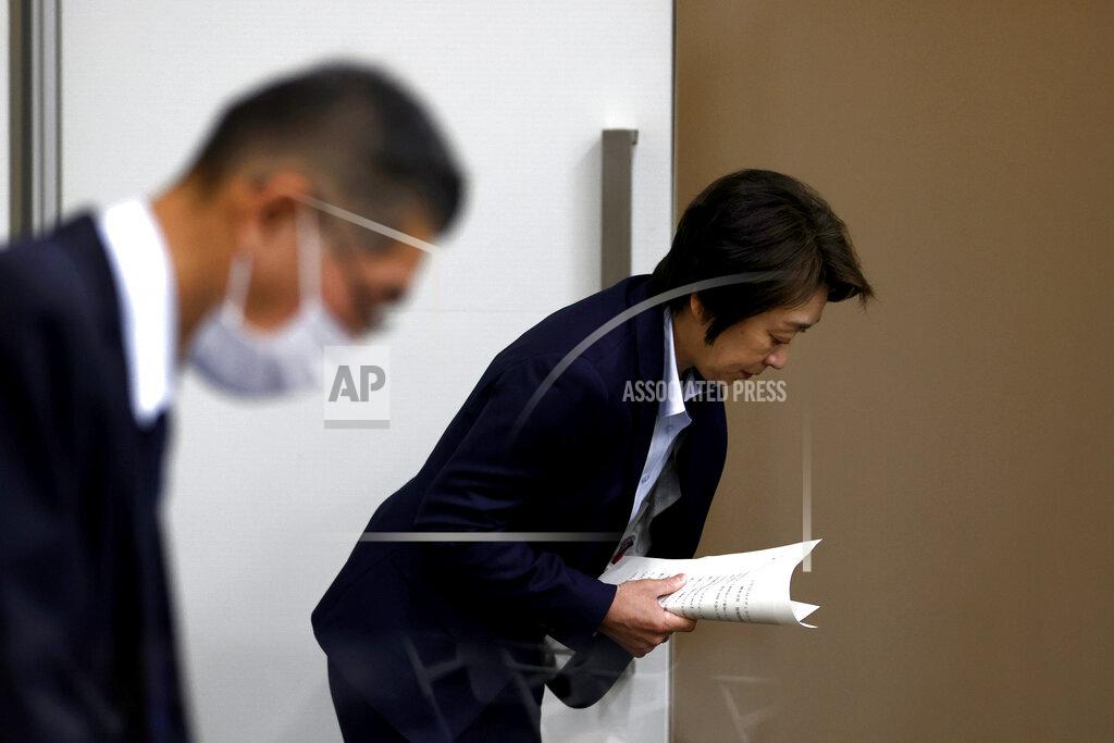 President of the Tokyo 2020 Olympics Organizing Committee Seiko Hashimoto, right, bows as she leaves after her speech at a press briefing on the operation and media coverage of Tokyo 2020 Olympic Torch Relay in Tokyo Thursday, Feb. 25, 2021. (Behrouz Mehri/Pool Photo via AP)