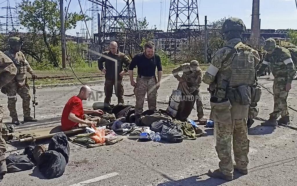 Uncredited In this photo taken from video released by the Russian Defense Ministry Press Service on Wednesday, May 18, 2022, Russian servicemen frisk Ukrainian servicemen after they leaved the besieged Azovstal steel plant in Mariupol, Ukraine.(Russian Defense Ministry Press Service via AP)