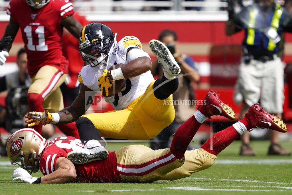 Tony Avelar Pittsburgh Steelers linebacker Devin Bush, top, falls over San Francisco 49ers tight end George Kittle after recovering a fumble by 49ers running back Raheem Mostert during the first half of an NFL football game in Santa Clara, Calif., Sunday, Sept. 22, 2019. (AP Photo/Tony Avelar)