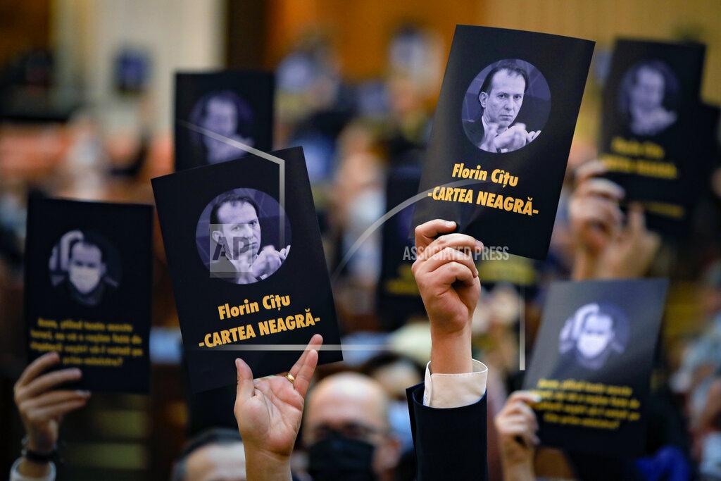 Vadim Ghirda Opposition members of parliament hold leaflets showing prime minister-designate Florin Citu, thet read "The Black Book" during a session called to vote on the government team in Bucharest, Romania, Wednesday, Dec. 23, 2020. Romania's president Klaus Iohannis appointed on Tuesday, the outgoing finance minister as prime minister-designate after three pro-Western center-right groups joined forces to keep out of power a left-leaning populist party that won most votes at a parliamentary election earlier this month. (AP Photo/Vadim Ghirda)