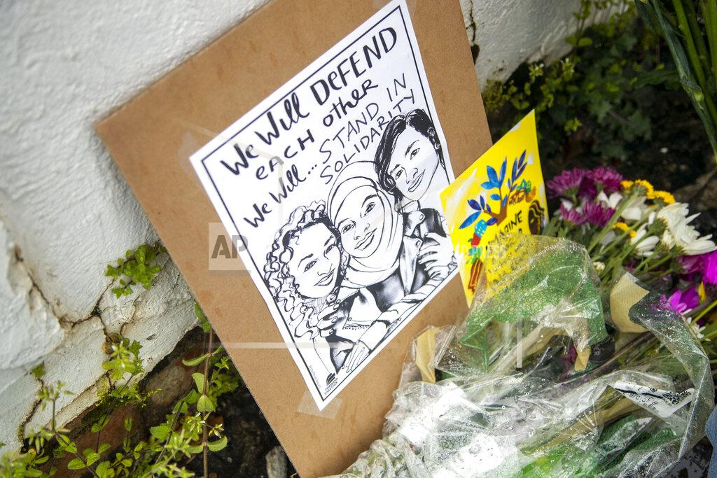Flowers, candles and signs are displayed at a makeshift memorial outside of the Gold Spa in Atlanta, Wednesday, March 17, 2021. According to authorities, three Asian women were found dead inside of the Gold Spa on Tuesday night and another Asian woman was found dead at Aromatherapy Spa across the street. Police in the Atlanta suburb of Gwinnett County say they've begun extra patrols in and around Asian businesses there following the shooting at three massage parlors in the area that killed eight, most of them women of Asian descent. (Alyssa Pointer/Atlanta Journal-Constitution via AP)