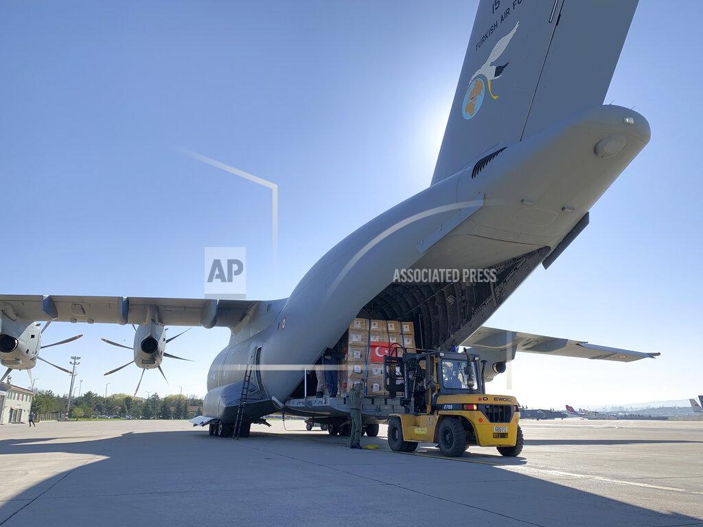 Uncredited In this handout photo provided by the Turkish Defense Ministry, Turkish soldiers prepare to load a military cargo plane with Personal Protection Equipment donated by Turkey to help United States combat the new coronavirus outbreak, at the Etimesgut airport outside Ankara, Turkey, Tuesday, April 28, 2020. Turkey is sending a planeload of surgical masks, N95 masks and hazmat suits to U.S. to help the country battle the coronavirus outbreak.(Turkish Defence Ministry via AP)