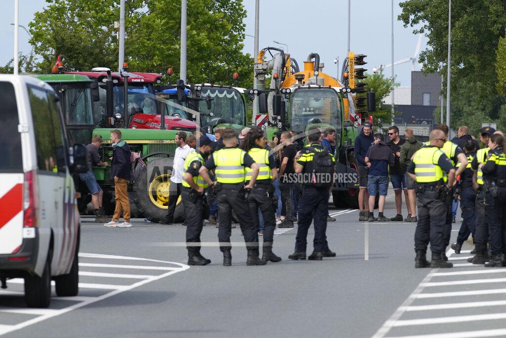 Peter Dejong Police looked on but did not immediately take action Monday as some 25 tractors set up a blockade outside a distribution center for supermarket chain Albert Heijn in the town of Zaandam, just north of Amsterdam, Monday, July 4, 2022. Dutch farmers angry at government plans to slash emissions used tractors and trucks Monday to blockade supermarket distribution centers, the latest actions in a summer of discontent in the country's lucrative agricultural sector. (AP Photo/Peter Dejong)