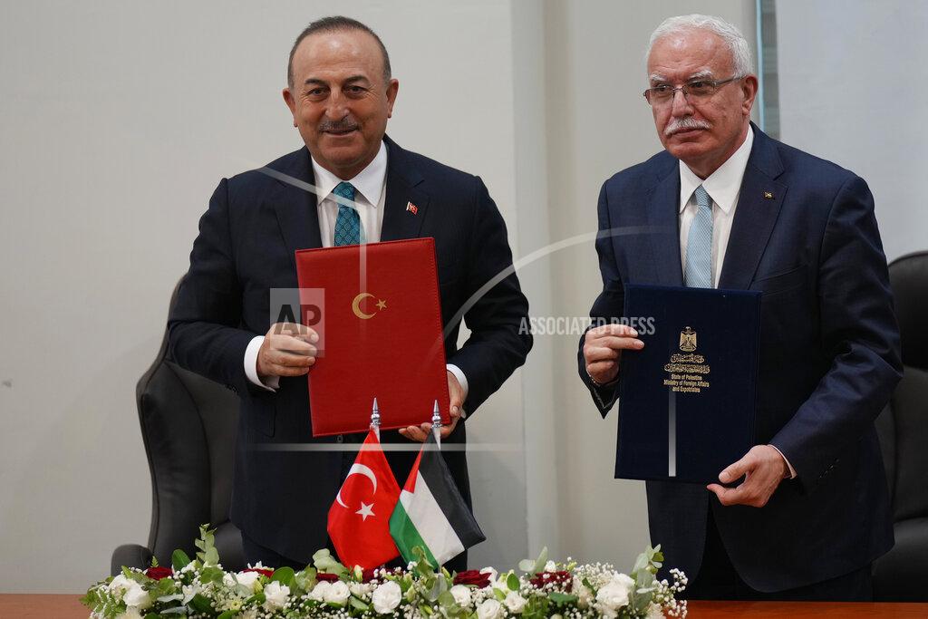 Majdi Mohammed Turkish Foreign Minister Mevlut Cavusoglu, left, and Palestinian Foreign Minister Riad al-Malki, hold documents as they pose for photographers in the West Bank town of Ramallah, Tuesday, May 24, 2022. (AP Photo/Majdi Mohammed)