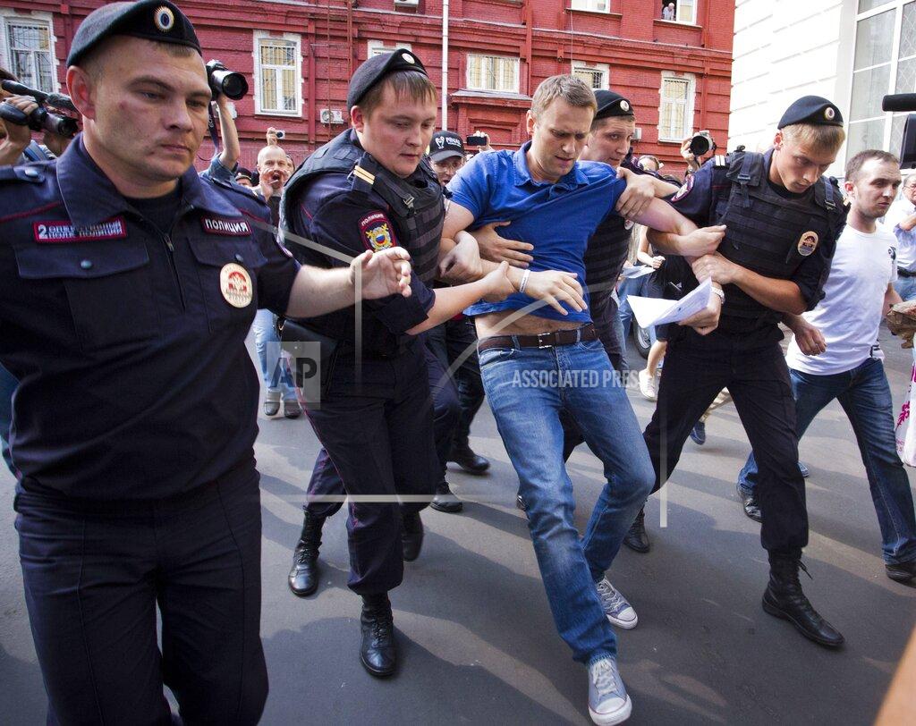 Evgeny Feldman FILE - In this file photo taken on Wednesday, July 10, 2013, police officers detain Russian opposition leader Alexei Navalny, center, in Moscow, Russia. Russian opposition politician Alexei Navalny is in a coma and on a ventilator in an intensive care unit in Siberia after falling ill from suspected poisoning that his allies believe is linked to his political activity. (AP Photo/Evgeny Feldman, File)
