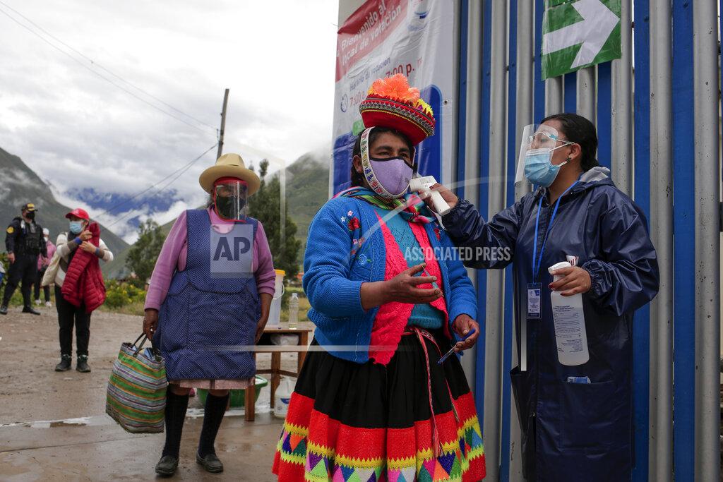 Sharon Castellanos Voters wearing masks to curb the spread of the new coronavirus have their temperature measured at the entrance of a polling station during general elections in Ollantaytambo, Peru, Sunday, April 11, 2021. (AP Photo/Sharon Castellanos)