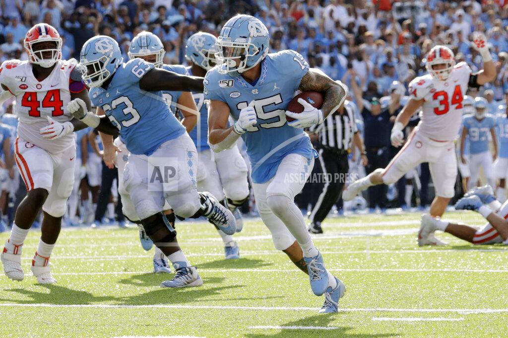 Chris Seward North Carolina's Beau Corrales (15) runs for a touchdown behind the block of Ed Montilus (63) while Clemson's Nyles Pinckney (44) looks on during the second quarter of an NCAA college football game in Chapel Hill, N.C., Saturday, Sept. 28, 2019. (AP Photo/Chris Seward)