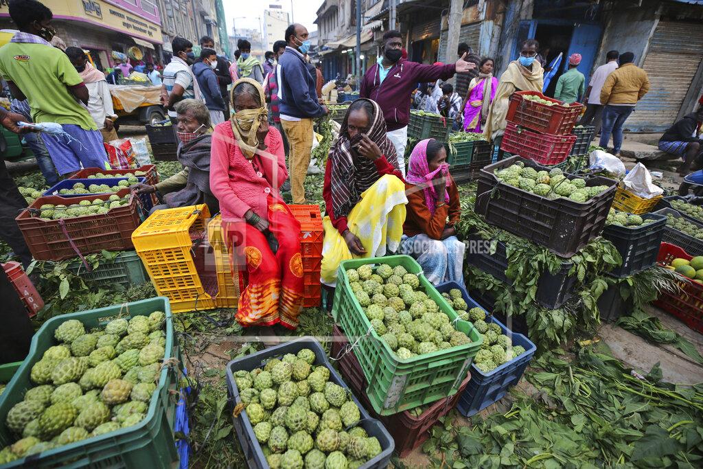 Aijaz Rahi Fruit vendors cover their faces as a precaution against the coronavirus and wait for buyers at a wholesale market in Bengaluru, India, Thursday, Sept. 24, 2020. In the April-June quarter, government figures show, activity in trade, hotels, transport, construction and communication declined by nearly half from a year earlier. Manufacturing contracted by about 40%. Despite the strains, there are some bright spots. Agriculture overall is growing at a 3.4% pace. With good monsoon rains, India might attain a record of 301 million metric tons of food-grain output, including wheat, rice, oil seeds, lentils and mustard, in the 2020-21 financial year, 4 million metric tons more than in 2019-20. (AP Photo/Aijaz Rahi)