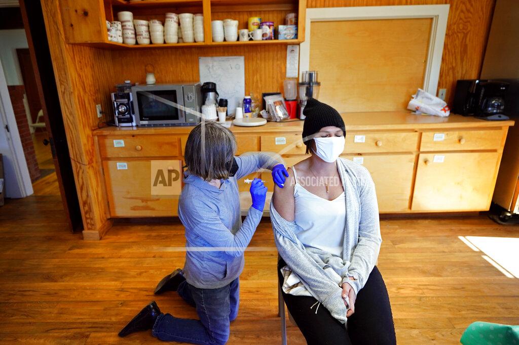 Robert F. Bukaty Nurse Sharon Daley, administers a COVID-19 vaccination to Hollie Stanley in a makeshift clinic in the kitchen of a community center, Friday, March 19, 2021, on Great Cranberry Island, Maine. (AP Photo/Robert F. Bukaty)