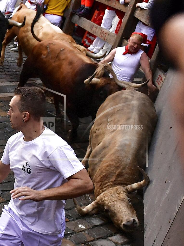 Alvaro Barrientos People run through the streets with fighting bulls and steers during the first day of the running of the bulls at the San Fermin Festival in Pamplona, northern Spain, Thursday, July 7, 2022. Revelers from around the world flock to Pamplona every year for nine days of uninterrupted partying in Pamplona's famed running of the bulls festival which was suspended for the past two years because of the coronavirus pandemic. (AP Photo/Alvaro Barrientos)