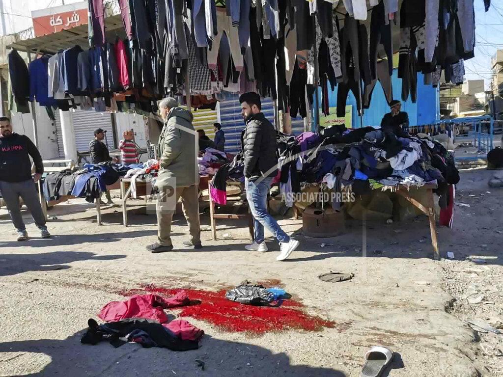 Hadi Mizban People and security forces gather at the site of a deadly bomb attack in Baghdad's bustling commercial area, Iraq, Thursday, Jan. 21, 2021. Twin suicide bombings hit Iraq's capital Thursday killing and wounding civilians, police and state TV said. (AP Photo/Hadi Mizban)