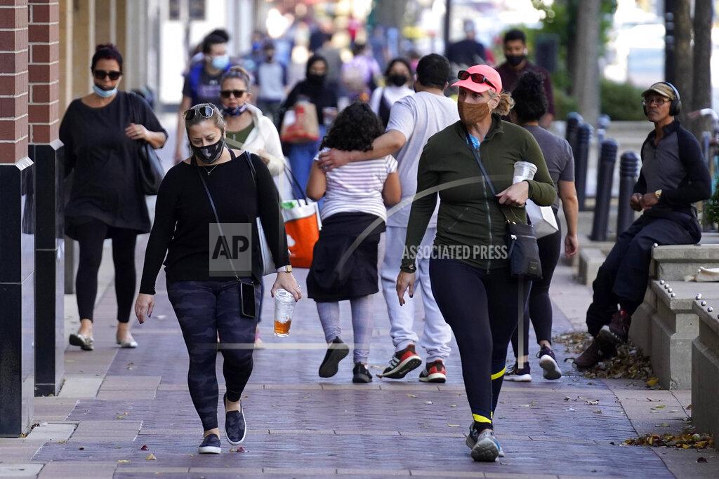 Nam Y. Huh FILE - In this Nov. 6, 2020, file photo, people walk in downtown Evanston, Ill. With the coronavirus coming back with a vengeance across the country and the U.S. facing a long, dark winter, governors and other elected officials are showing little appetite for reimposing the kind of lockdowns and large-scale business closings seen last spring. (AP Photo/Nam Y. Huh, File)
