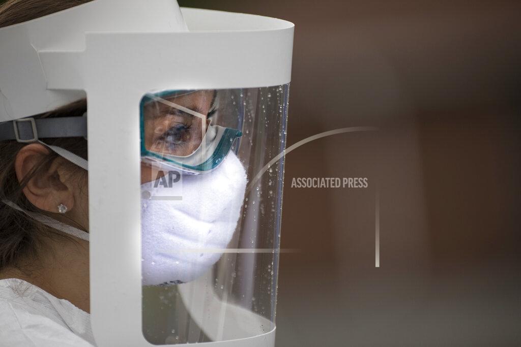 Emily Morris, an RN from Lifescreen, stands in full PPE at a pop up test site at the New Hope Baptist Church by Cempa Community care, Wednesday, May 27, 2020 in Chattanooga, Tenn. (Troy Stolt/Chattanooga Times Free Press via AP)