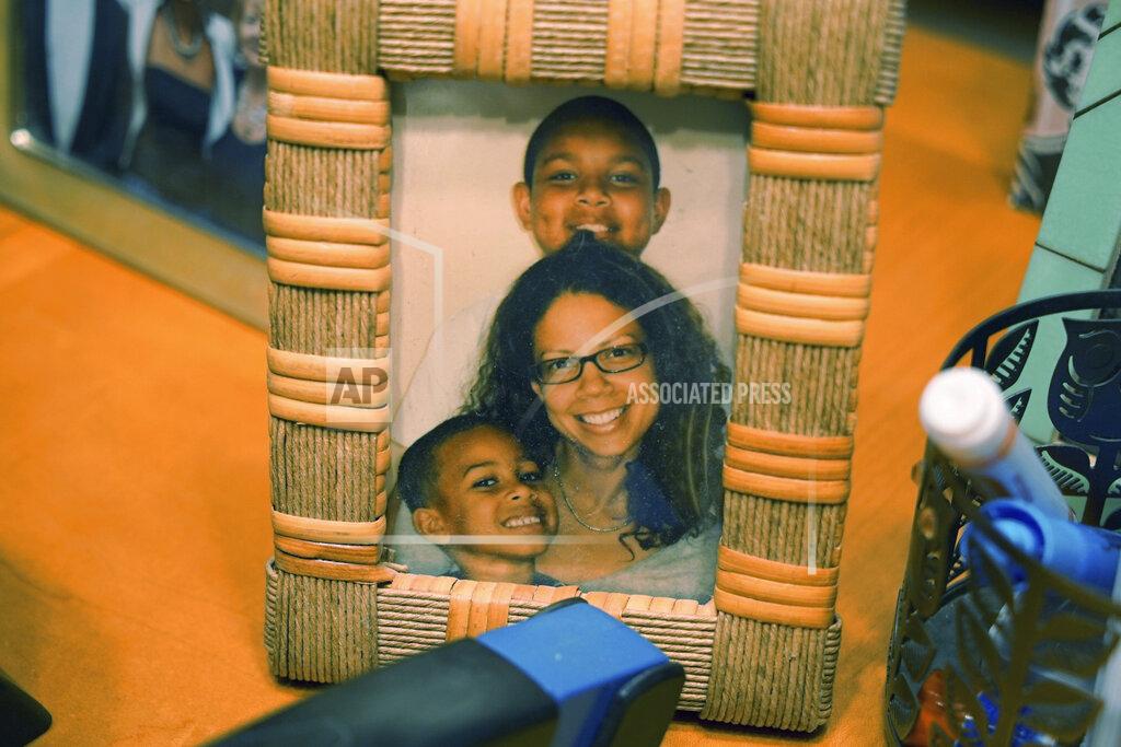 Allen G. Breed A photo of Alton Lucas' wife, Bronwyn Lucas, and their children, sits on a desk at his home outside of Raleigh, N.C., on Friday, June 18, 2021. His wife, whom he’d met at a fatherhood counseling conference, said his past had barred him from doing something as innocuous as chaperoning their children on school field trips. (AP Photo/Allen G. Breed)