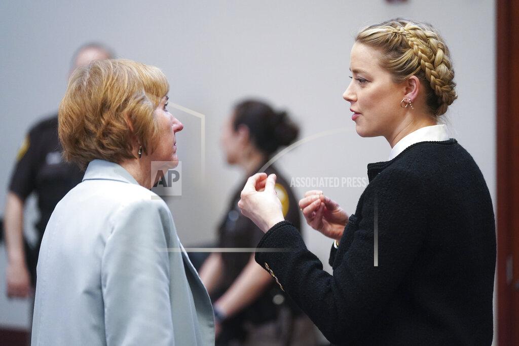 Shaw Thew Actor Amber Heard speaks with her attorney Elaine Bredehoft during a break at the Fairfax County Circuit Courthouse in Fairfax, Va., Thursday, May 19, 2022. Actor Johnny Depp sued his ex-wife Amber Heard for libel in Fairfax County Circuit Court after she wrote an op-ed piece in The Washington Post in 2018 referring to herself as a "public figure representing domestic abuse." (Shawn Thew/Pool Photo via AP)