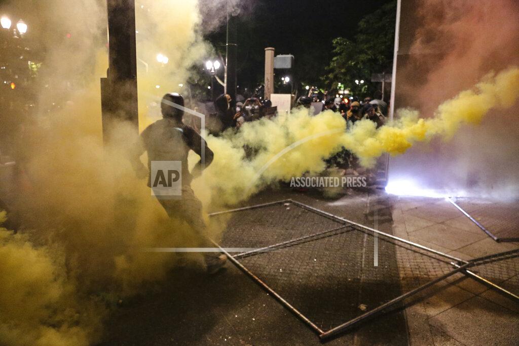 Police respond to protesters during a demonstration, Friday, July 17, 2020 in Portland, Ore. Militarized federal agents deployed by the president to Portland, Oregon, fired tear gas against protesters again overnight as the city’s mayor demanded that the agents be removed and as the state’s attorney general vowed to seek a restraining order against them. (Dave Killen/The Oregonian via AP)