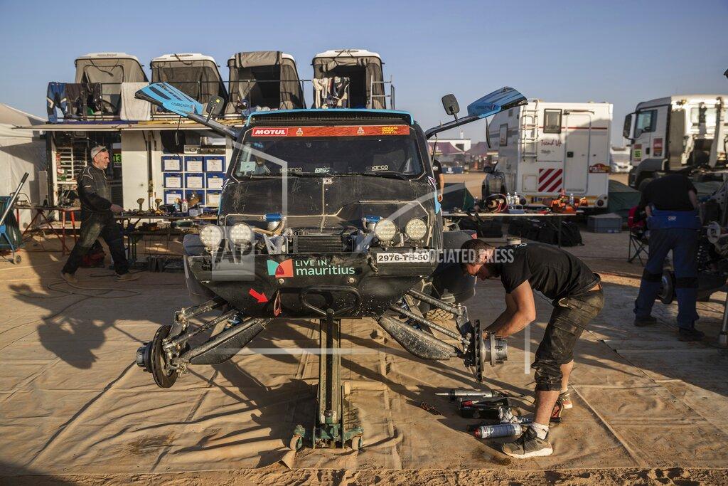 Bernat Armangue In this Monday, Jan. 13, 2020 photo, a mechanic works on a car after stage eight of the Dakar Rally in Wadi Al Dawasir, Saudi Arabia. Formerly known as the Paris-Dakar Rally, the race was created by Thierry Sabine after he got lost in the Libyan desert in 1977. Until 2008, the rallies raced across Africa, but threats in Mauritania led organizers to cancel that year's event and move it to South America. It has now shifted to Saudi Arabia. The race started on Jan. 5 with 560 drivers and co-drivers, some on motorbikes, others in cars or in trucks. Only 41 are taking part in the Original category. (AP Photo/Bernat Armangue)