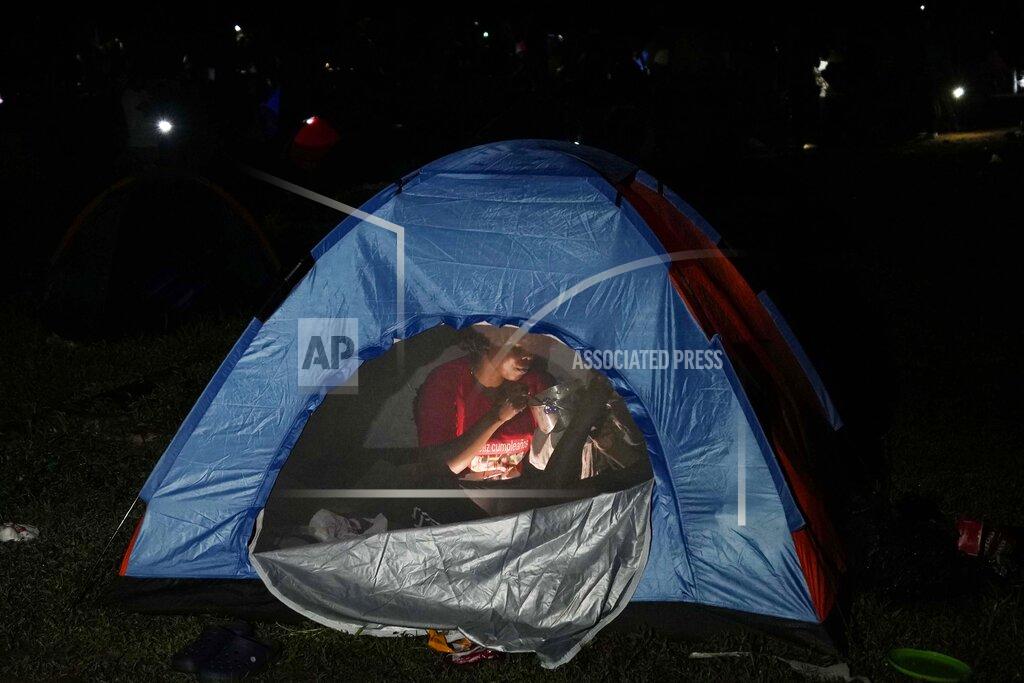 Fernando Vergara A migrant eats breakfast inside her tent at a camp in Acandi, Colombia, Wednesday, Sept. 15, 2021. The migrants, following a well-beaten, multi-nation journey towards the U.S., will continue their journey through the jungle known as the Darien Gap. (AP Photo/Fernando Vergara)