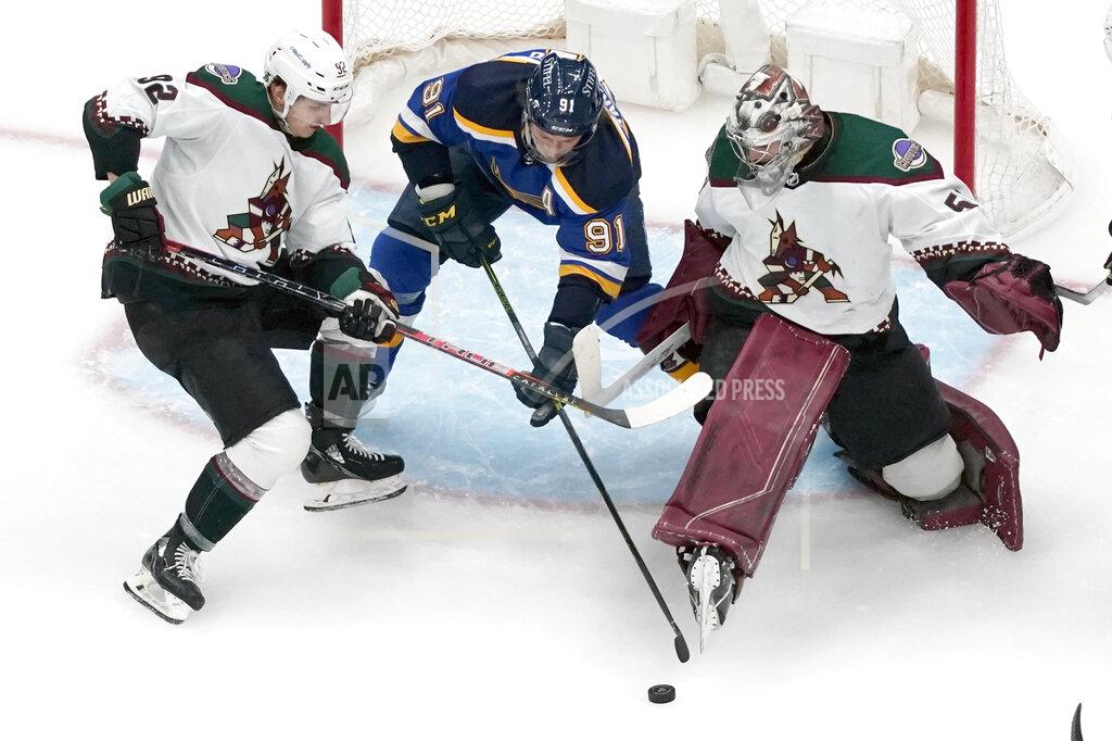 Jeff Roberson St. Louis Blues' Vladimir Tarasenko (91) reaches for a loose puck between Arizona Coyotes goaltender Ivan Prosvetov and Vladislav Kolyachonok, left, during the third period of an NHL hockey game Monday, April 4, 2022, in St. Louis. (AP Photo/Jeff Roberson)
