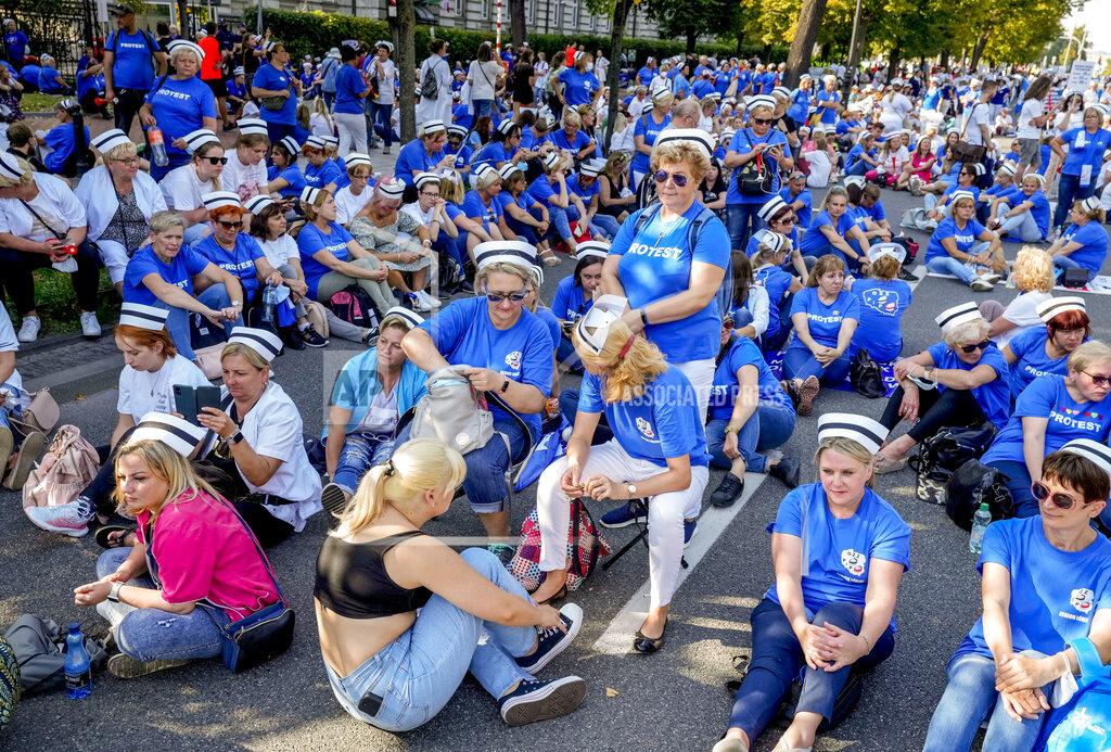 Czarek Sokolowski Medical stuff sit on the road protesting in front of the Chancellery in Warsaw, Poland, Saturday, Sept.11, 2021. (AP Photo/Czarek Sokolowski)