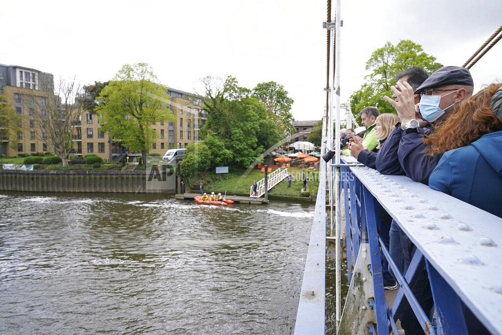Yui Mok An RNLI boat and crew prepare whilst people gather to spot Minke whale, which was freed on Sunday after it became stuck on Richmond lock's boat rollers but has remained in the Thames, is seen near Teddington Lock in London, Monday, May 10, 2021. A Port of London Authority spokesperson said a whale had never been seen this far up the Thames before, some 95 miles from its mouth. (Yui Mok/PA via AP)