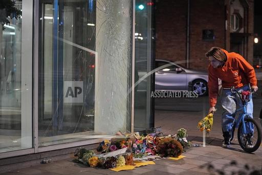 Flowers laid in tribute outside an office building in Brussels, Tuesday evening, Oct. 17, 2023, close to where two Swedish soccer fans were shot by a suspected Tunisian extremist on Monday night. Police in Belgium have shot dead a suspected Tunisian extremist accused of killing two Swedish soccer fans in a brazen attack on a Brussels street before disappearing into the night on Monday. (AP Photo/Martin Meissner)