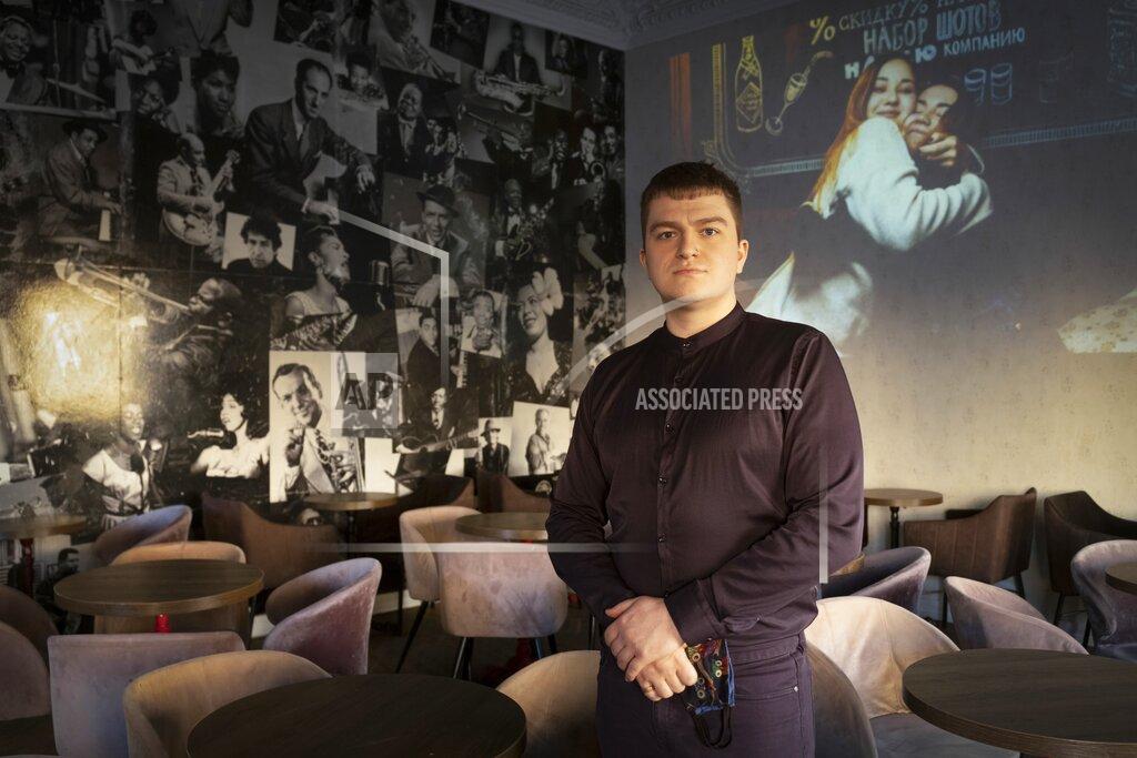 Dmitri Lovetsky Mikhail Kavin, manager of the Commode bar in St. Petersburg, Russia, poses for a photo prior to his interview with The Associated Press on Wednesday, March 24, 2021. Police raided the bar in December for serving customers behind closed doors past 11 p.m. in violation of coronavirus restrictions. Even with flouting the rules, the bar hasn't bounced back to its pre-pandemic level of sales, Kavin said. (AP Photo/Dmitri Lovetsky)