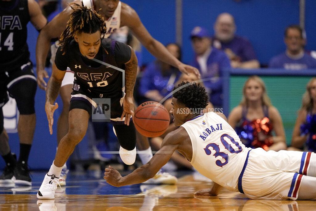 Charlie Riedel Kansas' Ochai Agbaji (30) and Stephen F. Austin's Latrell Jossell (10) chase after a loose ball during the second half of an NCAA college basketball game Saturday, Dec. 18, 2021, in Lawrence, Kan. (AP Photo/Charlie Riedel)