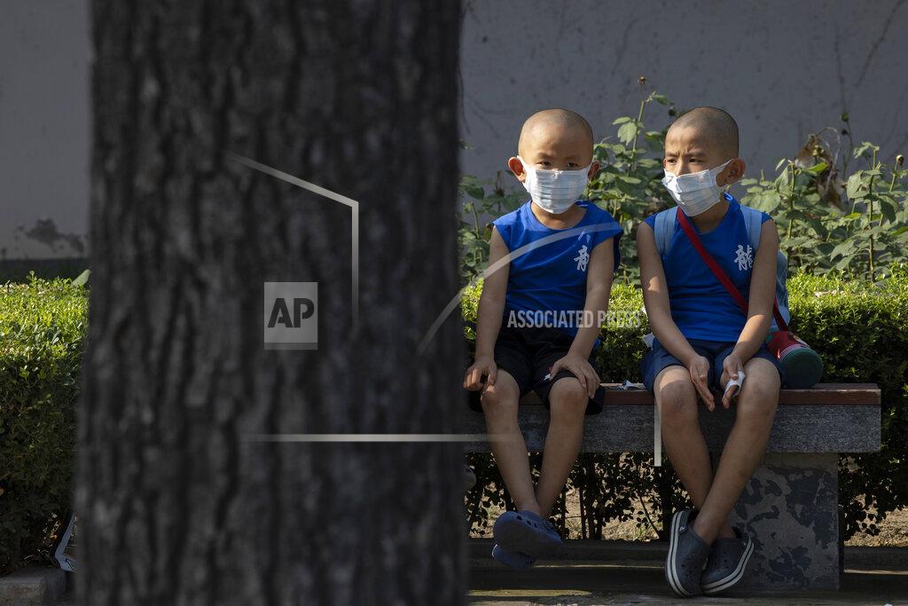 Ng Han Guan Children wearing masks to curb the spread of the coronavirus sit on a bench in Beijing, China on Monday, July 13, 2020. China reported only a handful of new cases of the virus, all of them brought from outside the country, as domestic community infections fall to near zero. (AP Photo/Ng Han Guan)